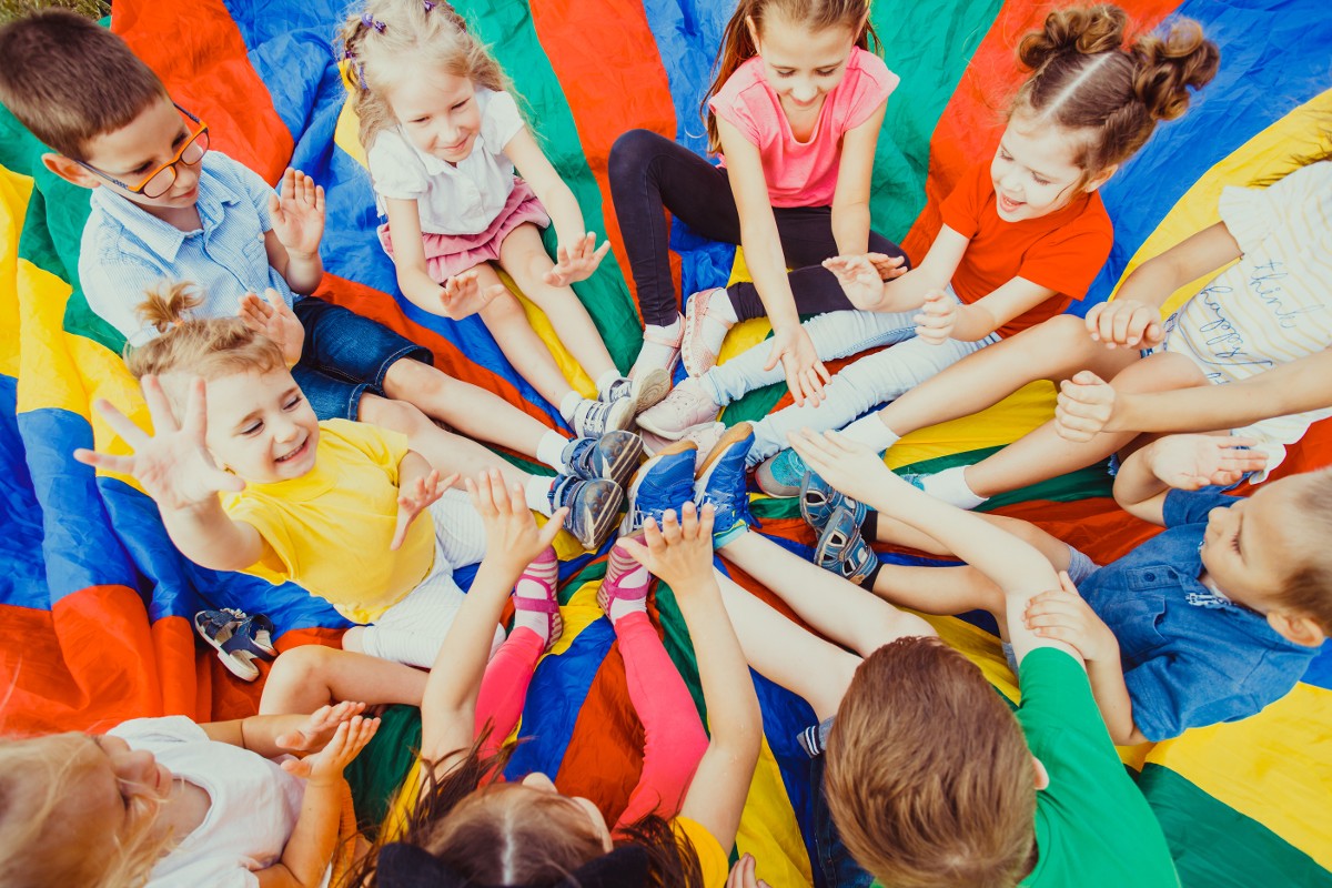 Kinder spielen auf einer bunten Decke