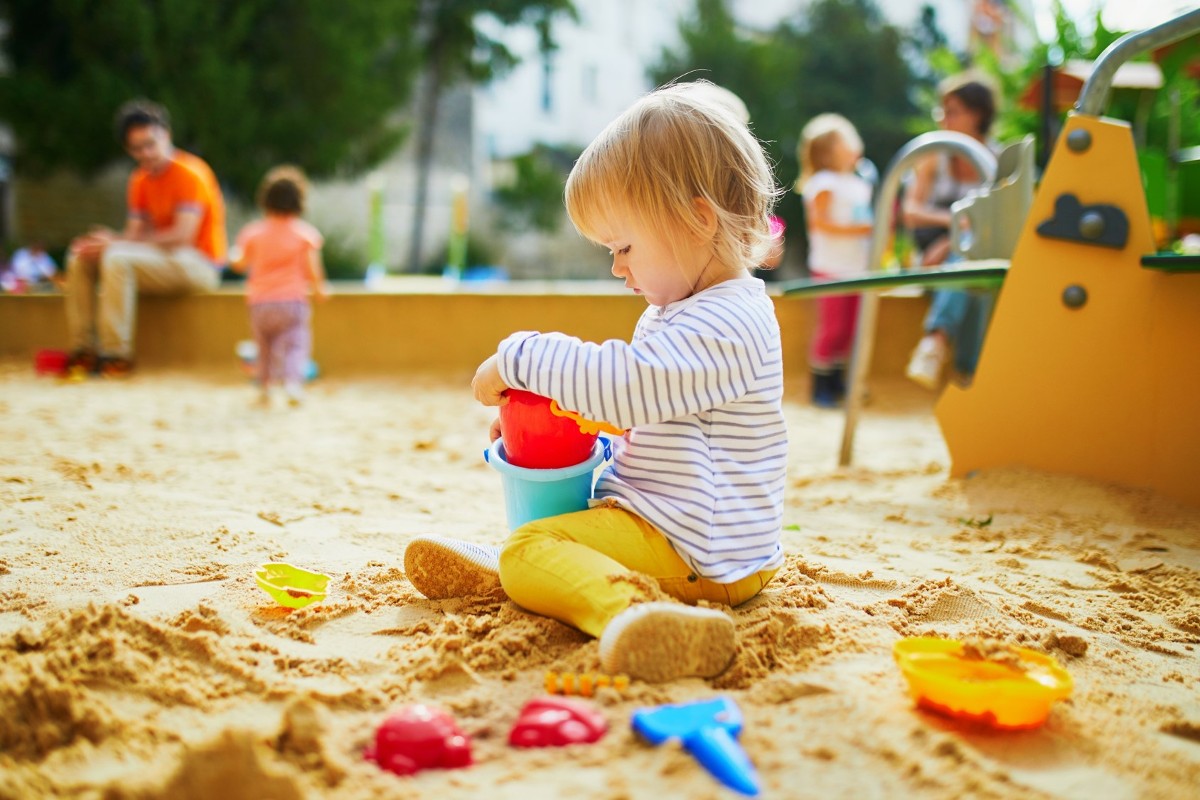 Kleines Mädchen spielt in einer Sandkiste